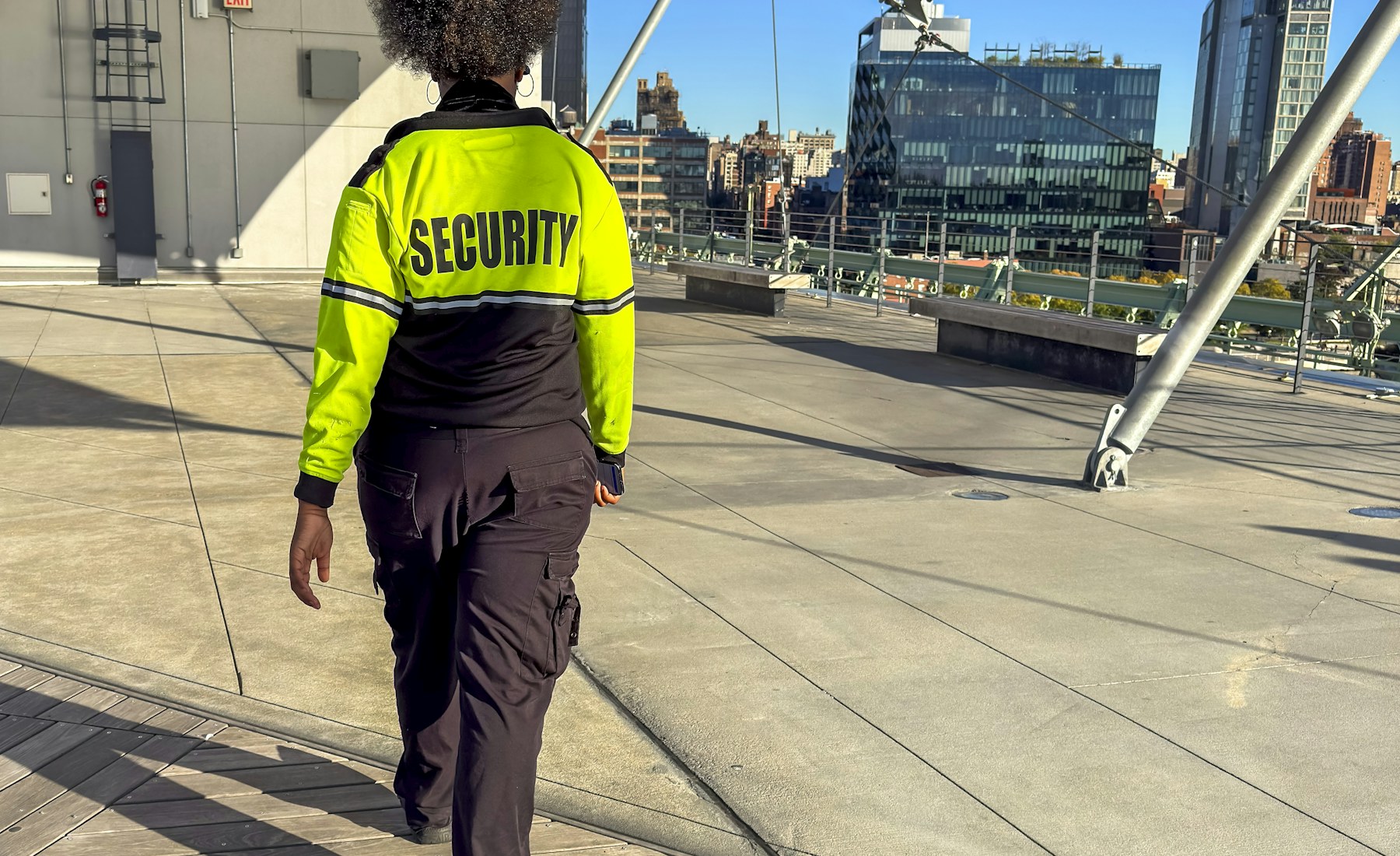Security officer walking on a rooftop in a city